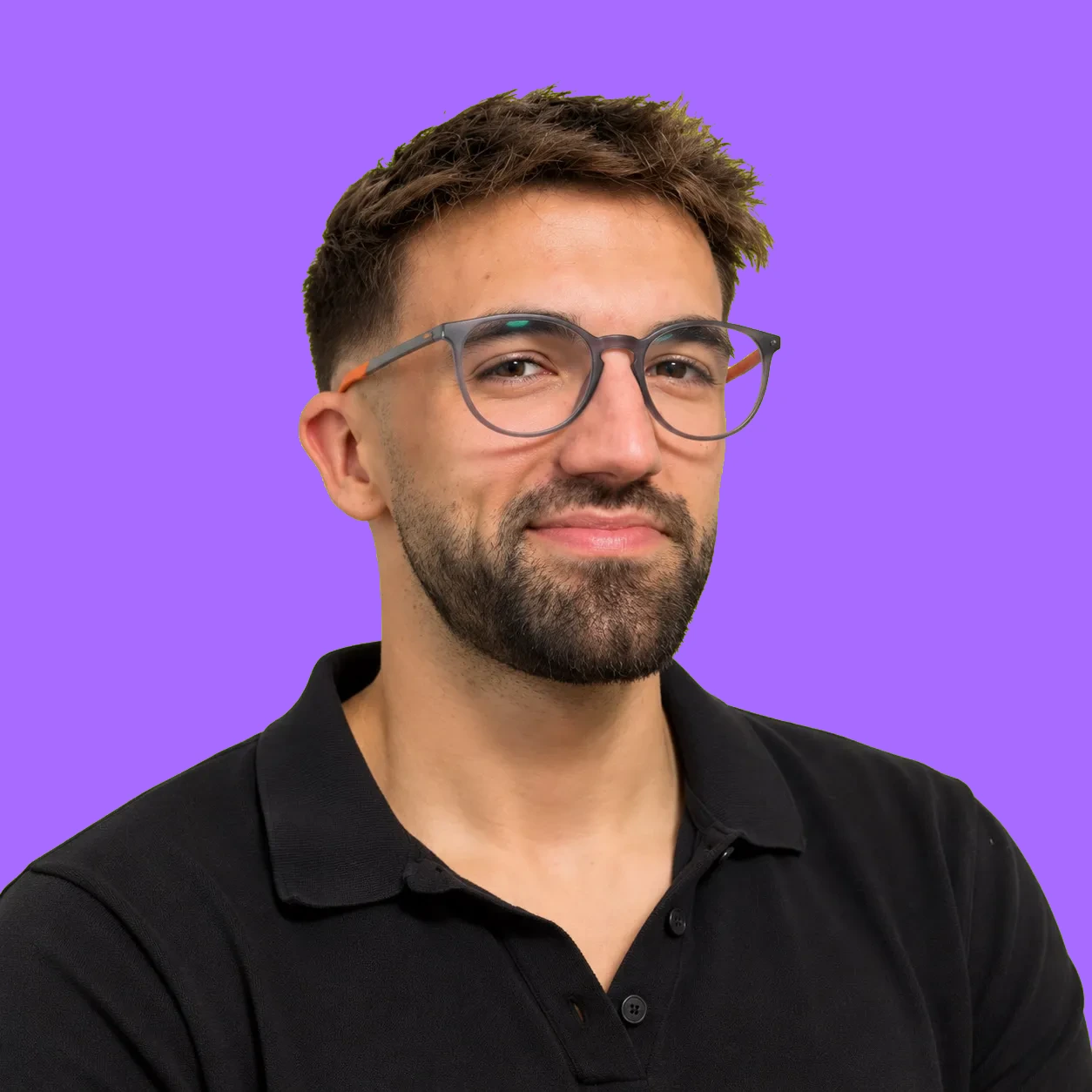 Retrato de Javier Wiott sonriendo, con gafas y polo negro, sobre fondo verde lima
